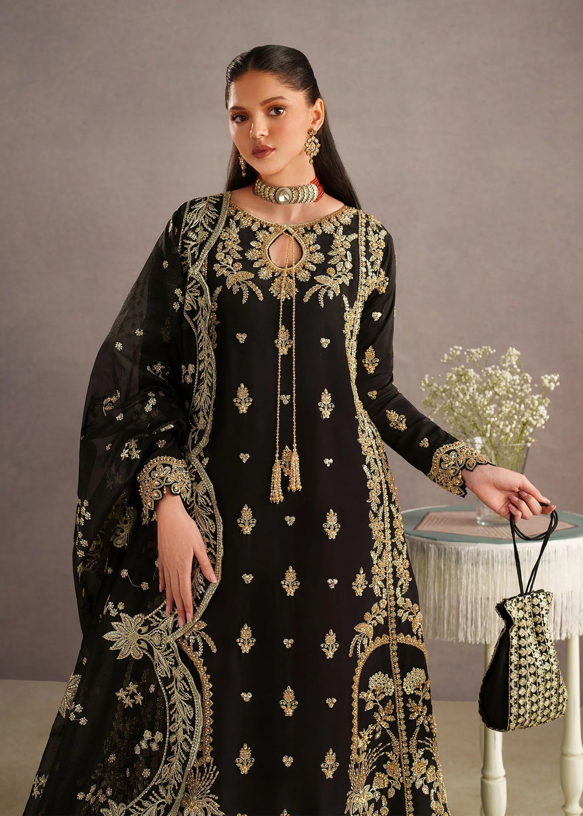 Woman posing in a stylish black Leia embroidered tissue silk 3 piece outfit from the Dastoor collection, featured at Buraq Store
