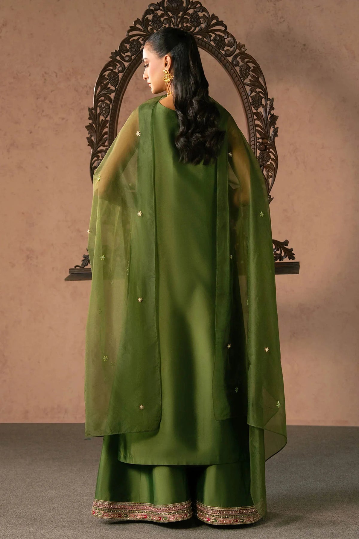 Woman posing in a stylish green Esma tissue silk 3 piece outfit from the Dastoor collection, featured at Buraq Store