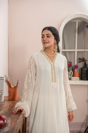 Woman wearing an off white embroidered chiffon pret 3 piece from the Manahils collection, featured at Buraq Store