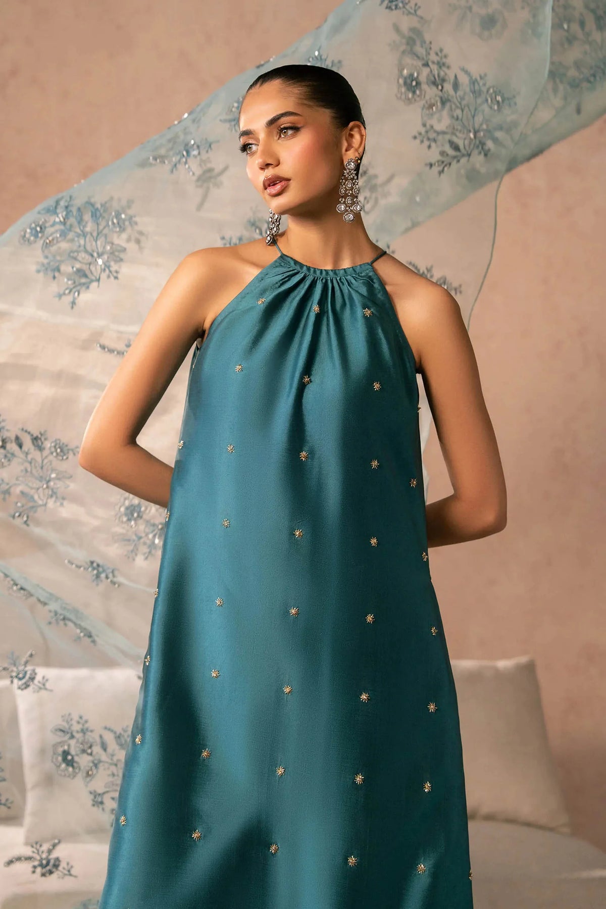 Woman posing in a stylish teal blue Zenia tissue silk 3 piece outfit from the Dastoor collection PK, featured at Buraq Store