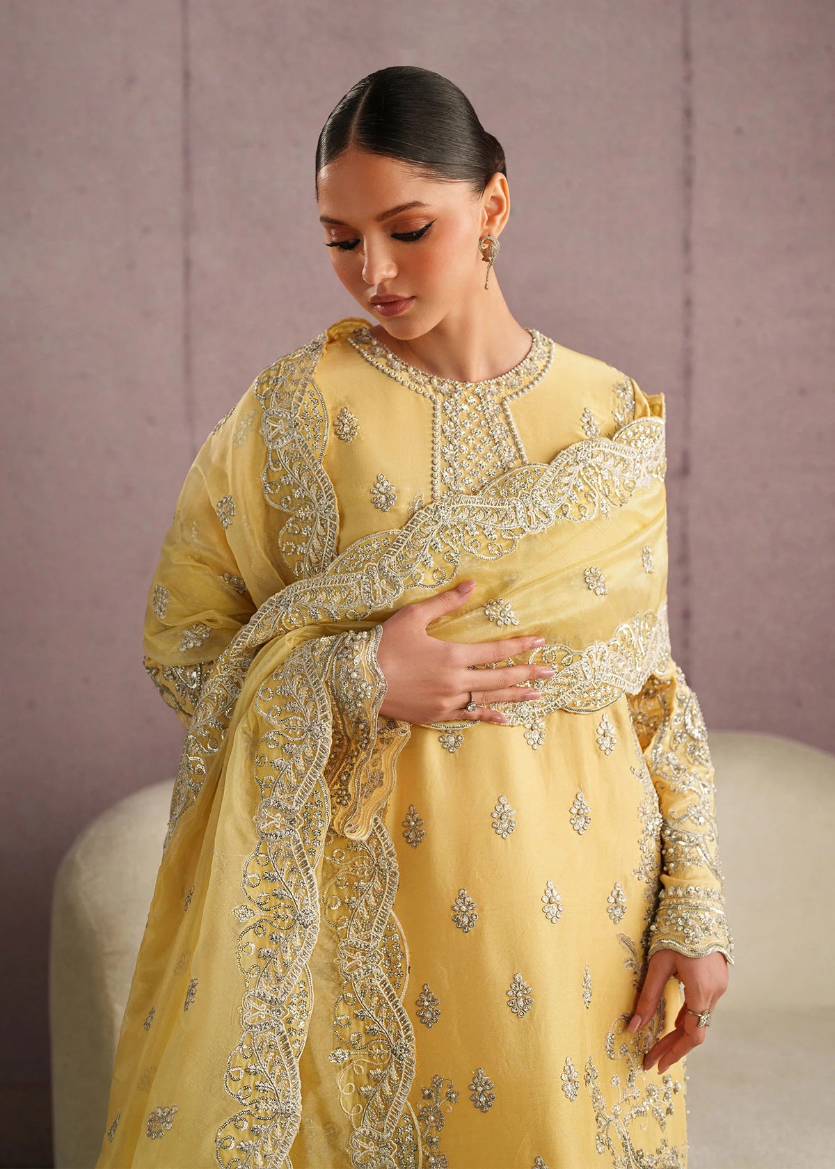 Woman posing in a stylish yellow Leora embroidered tissue silk 3 piece outfit from the Dastoor collection, featured at Buraq Store