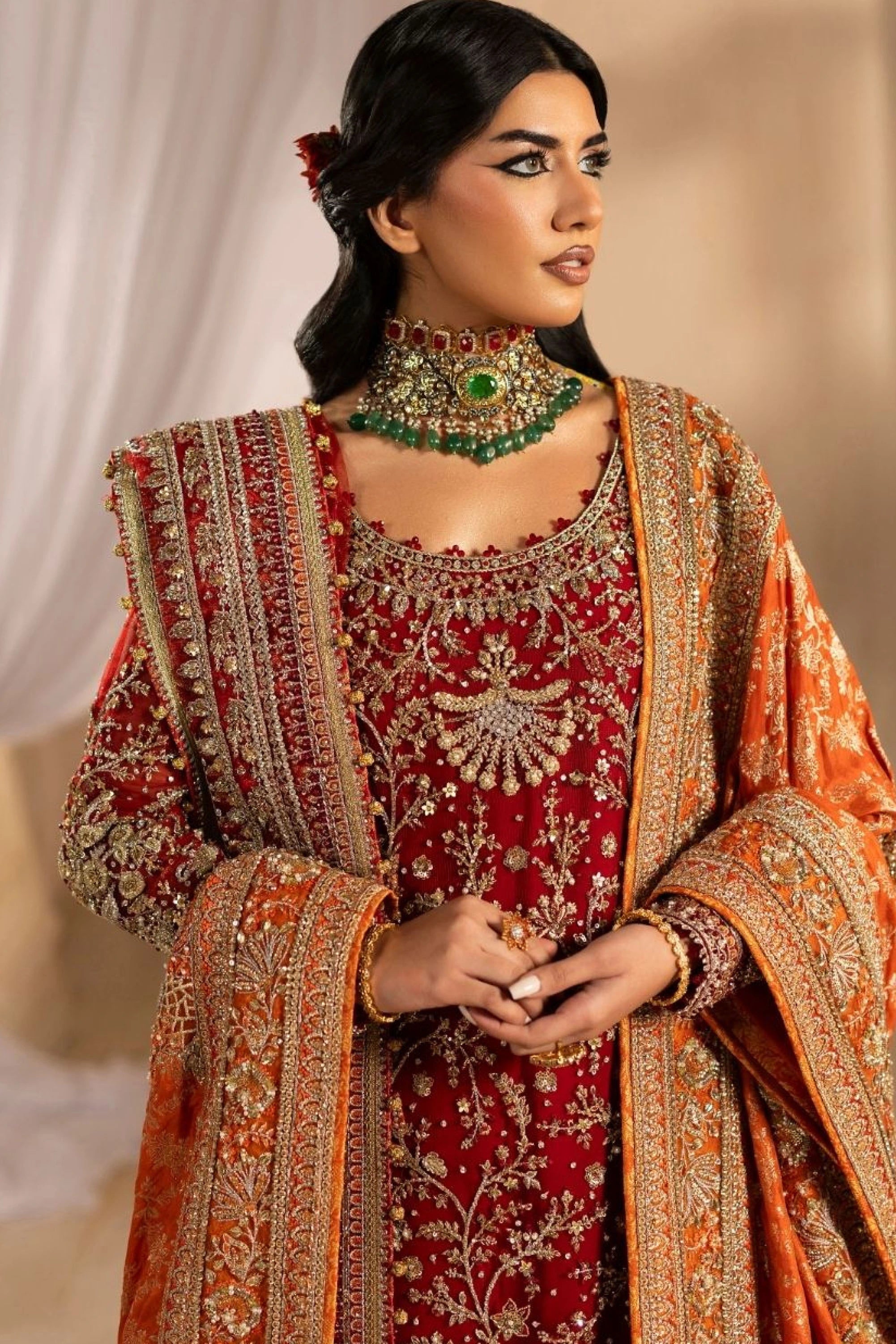 Buraqstore bride posing in full red bridal dress with luxurious detailing and dupatta