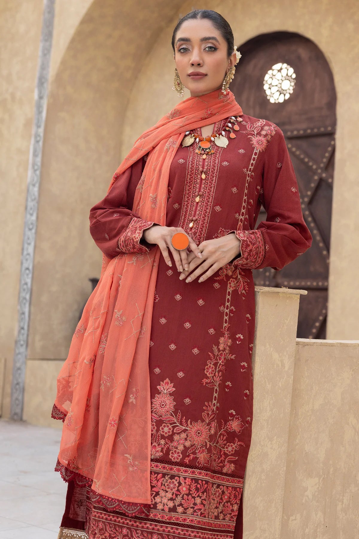 Buraqstore girl posing in warm red colour dress karandi fabric with traditional embroidery details