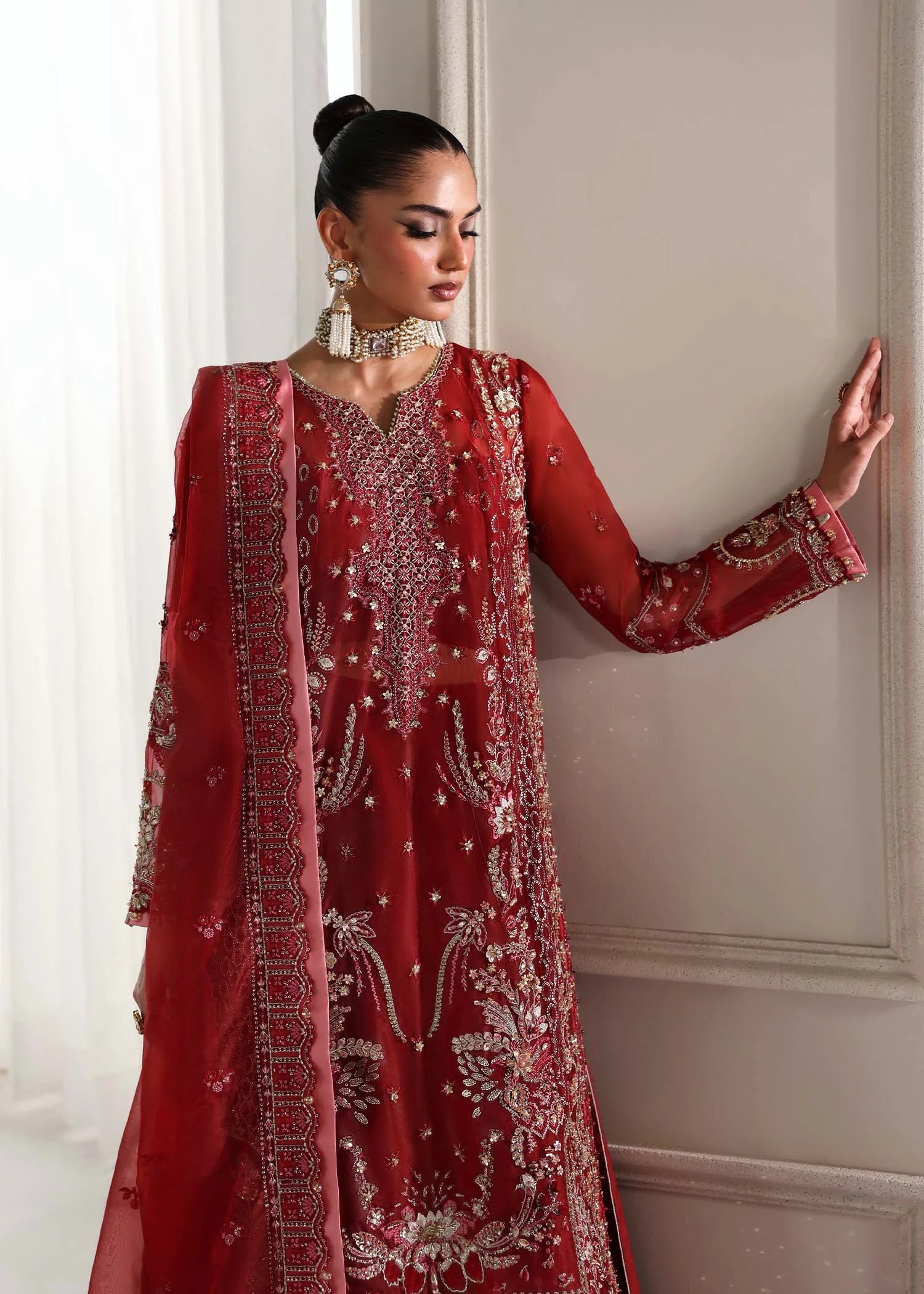 Buraqstore bride posing in full red bridal dress with layered organza frock and dupatta styling
