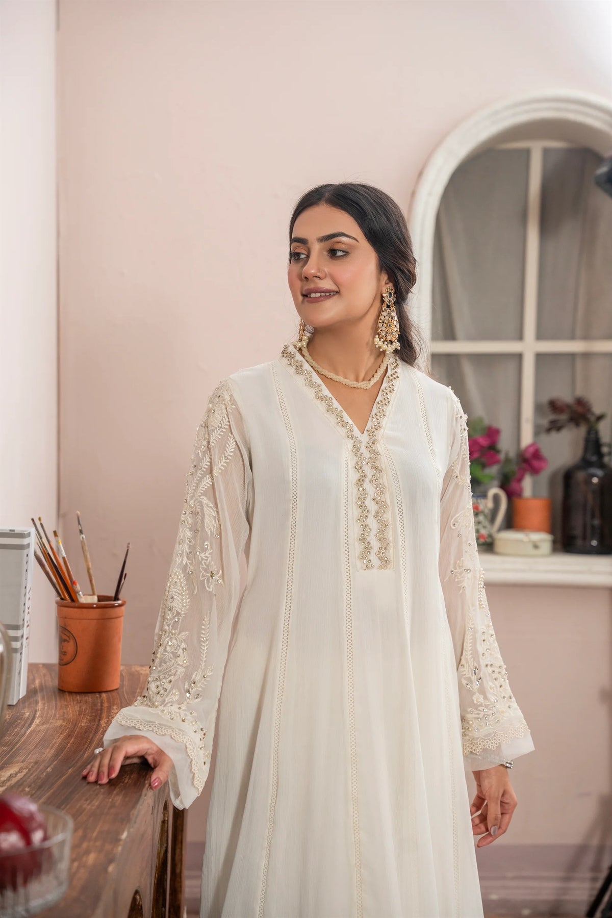 Woman wearing an off white embroidered chiffon pret 3 piece from the Manahils collection, featured at Buraq Store