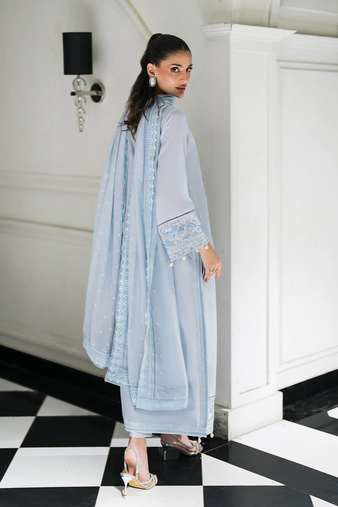 Woman posing in an elegant powder blue lawn suit from Sidra Fahad official, featured at Buraq Store