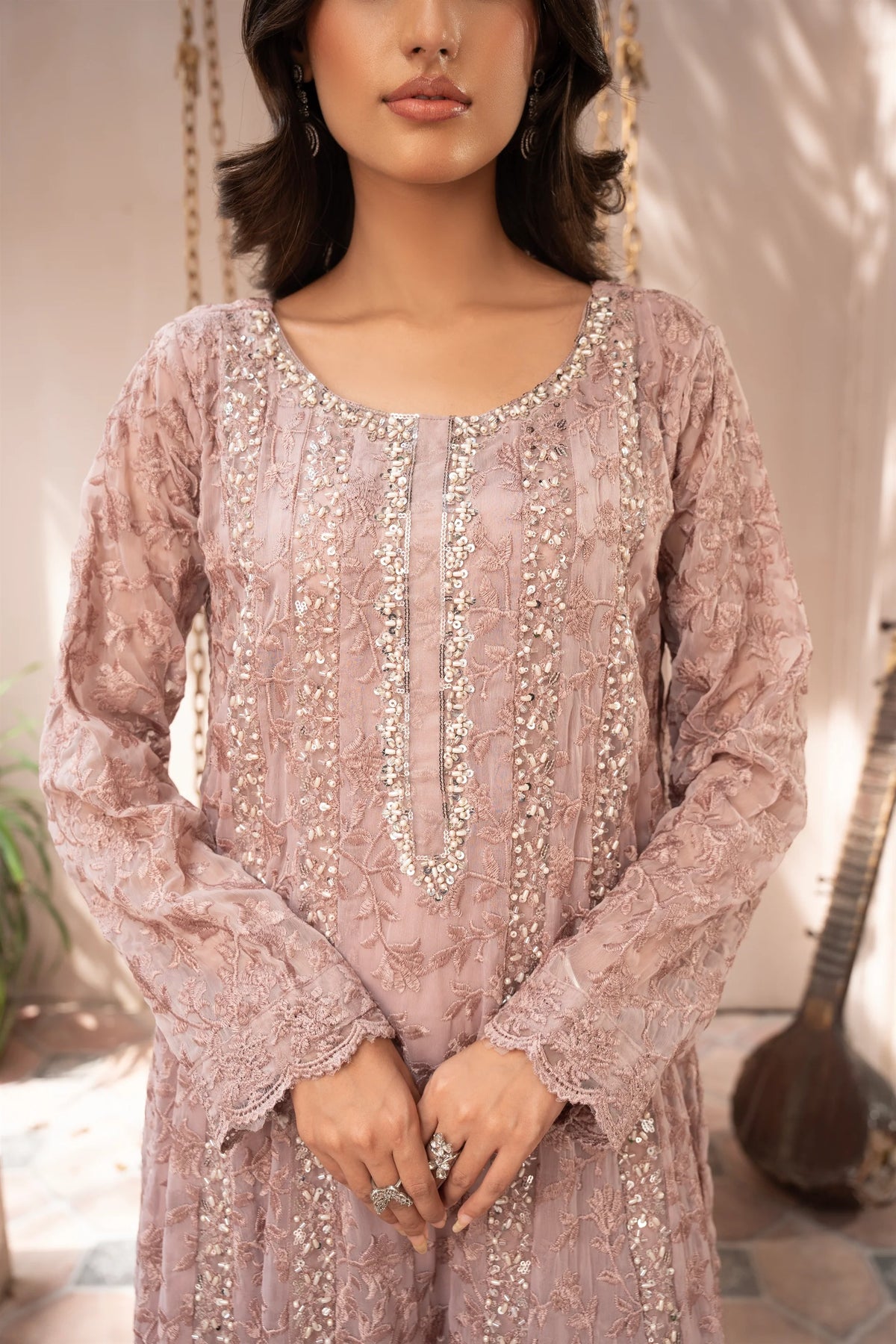 Woman wearing a tea rose pink embroidered chiffon pret 3 piece from the Manahils collection, featured at Buraq Store