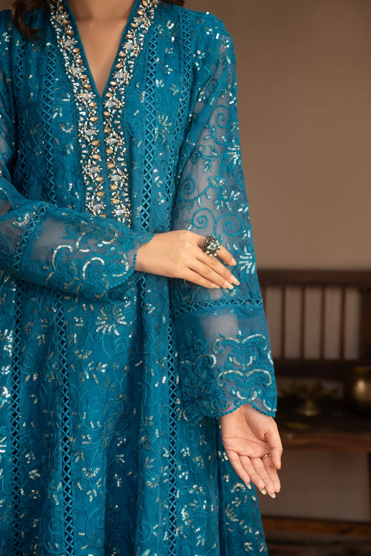 Woman wearing a teal embroidered organza pret 3 piece from the Manahils collection, featured at Buraq Store