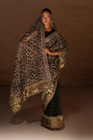 Women wearing black designer saree pakistan in organza with abstract metallic foil print, front view from Buraqstore