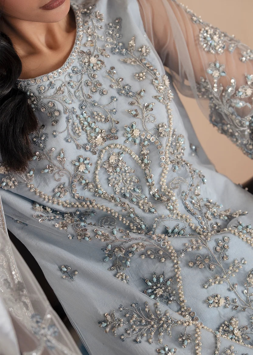 Model wearing ice blue color dress, side view showing the flare of the gharara, Buraqstore