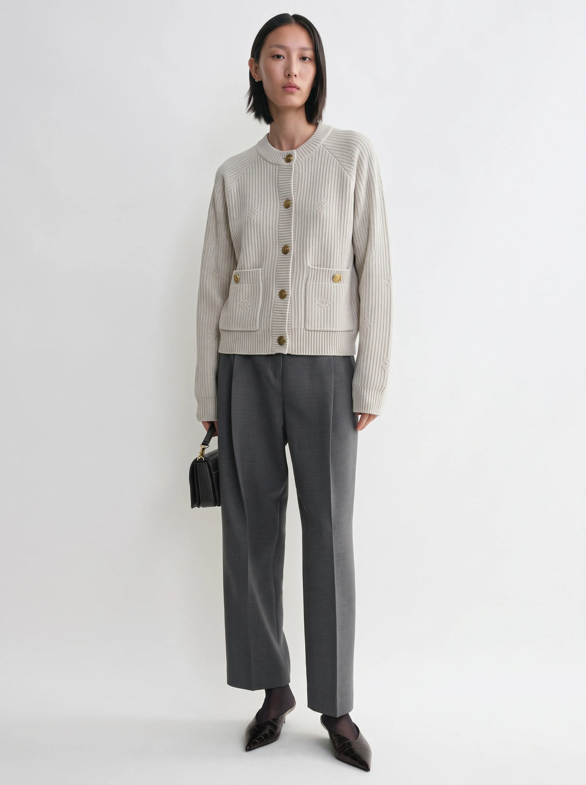 Model wearing cardigan women love in ivory, a buttoned knit cardigan with pockets, front view from Buraqstore