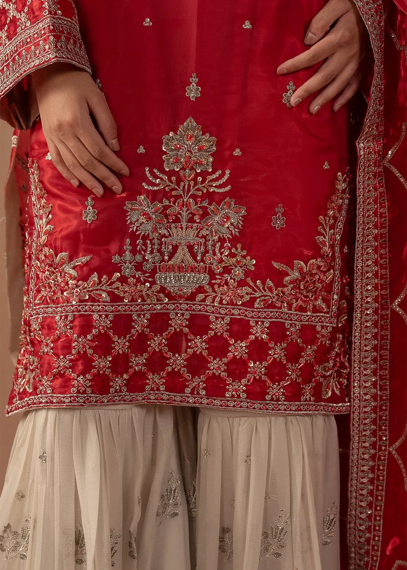 Model wearing red colour dress pakistani, side view showing the fall of the silk shirt and chiffon trouser, Buraqstore