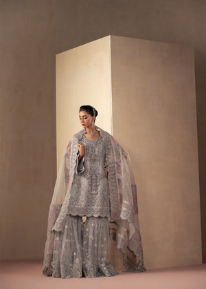 Model wearing silver colour dress as a festive outfit, shop the embroidered gharara 3-piece set at Buraqstore