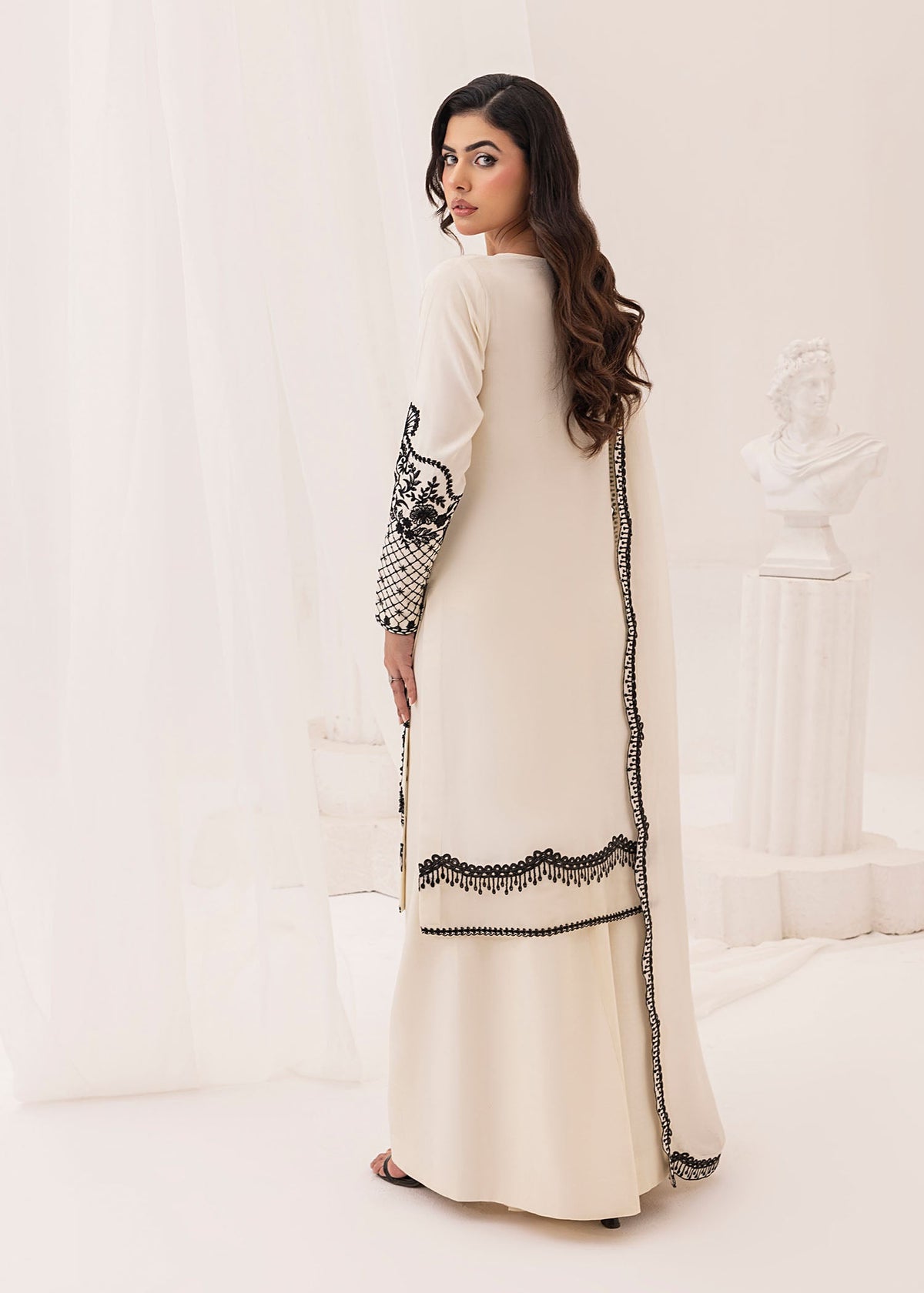 Model showcasing a white and black Jamnii silk 3 piece suit at Buraq Store