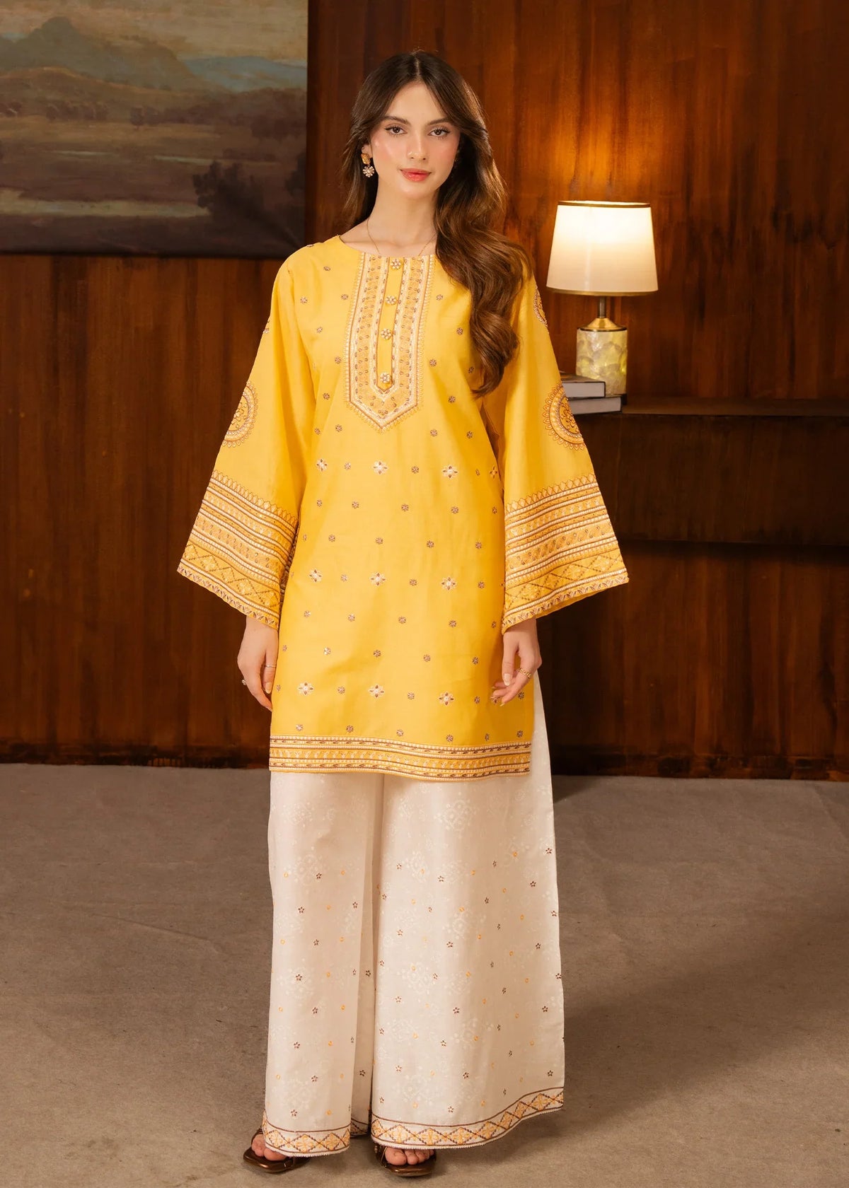 Model wearing yellow dress design finished in white, embroidered lawn 2PC set, front view from Buraqstore
